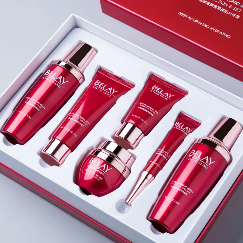 Facial care cosmetics set with six red and silver skincare bottles and tubes in a white box