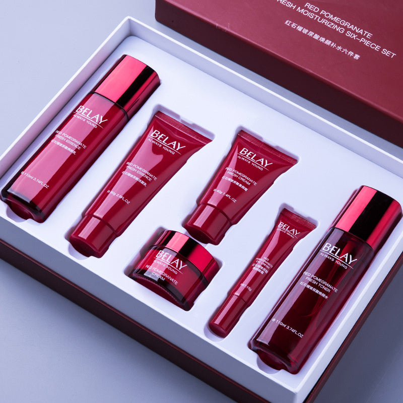 Red pomegranate facial care cosmetics set with moisturizing cream and serum in elegant red packaging