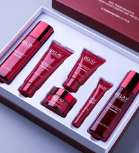 Red pomegranate facial care cosmetics set with moisturizing cream and serum in elegant red packaging