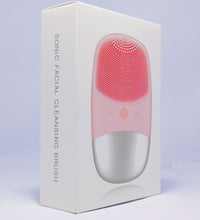Electric silicone face cleansing brush in pink and silver shown on white product packaging box