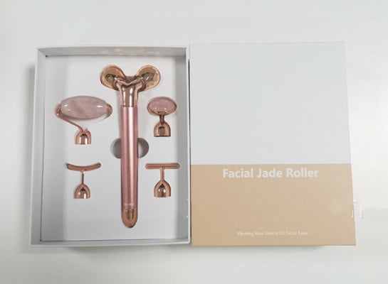 Rose gold 5-in-1 facial massage tool set with various jade roller attachments in white and beige box