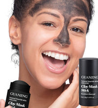 Smiling woman applying organic bamboo charcoal face mask with GuanJing clay mask stick