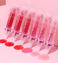 Set of six lip plumper with chili extract tubes in various shades on pink background