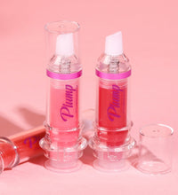 Two clear tubes of lip plumper with chili extract in pink and red shades on a pink background