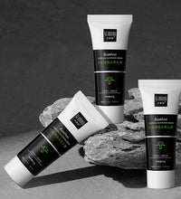 Bamboo charcoal blackhead remover cream tubes arranged on gray rocks with black and white packaging
