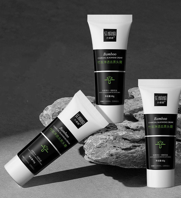 Bamboo charcoal blackhead remover cream tubes arranged on gray rocks with black and white packaging