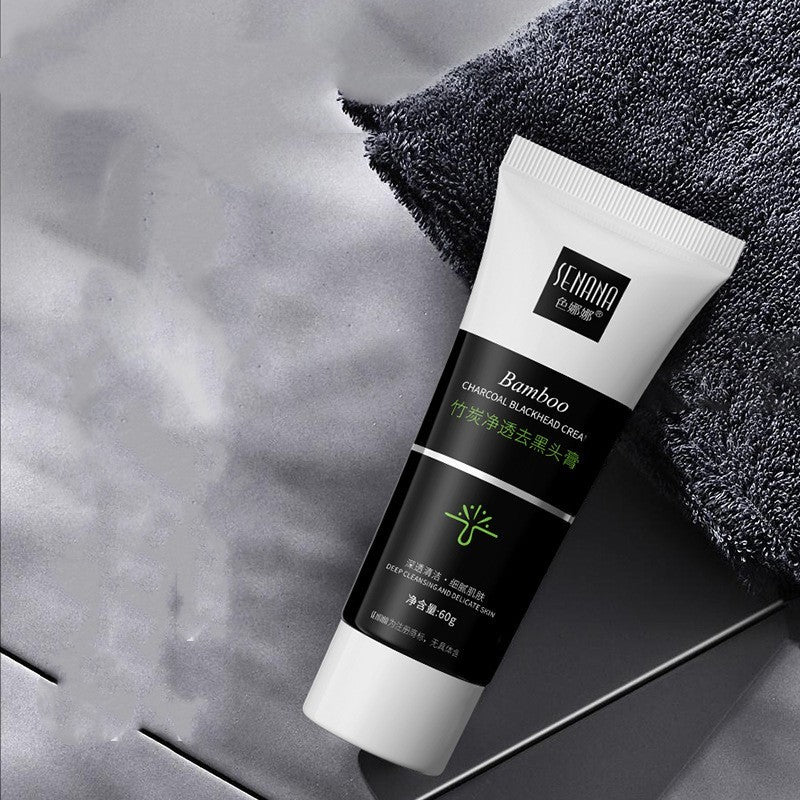 Tube of bamboo charcoal blackhead remover cream on gray surface next to a dark textured towel