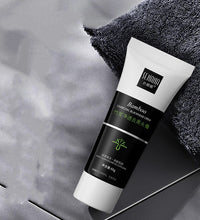 Tube of bamboo charcoal blackhead remover cream on gray surface next to a dark textured towel