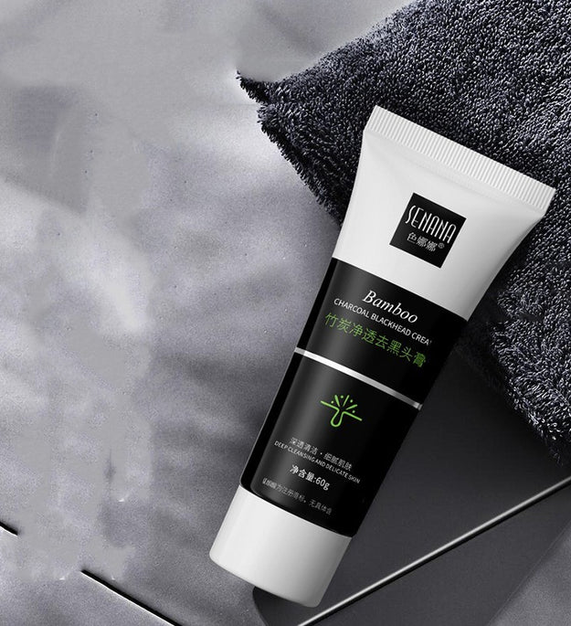 Bamboo charcoal blackhead remover cream tubes arranged on gray rocks with black and white packaging