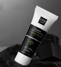 Tube of bamboo charcoal blackhead remover cream with black and white packaging on natural black charcoal background