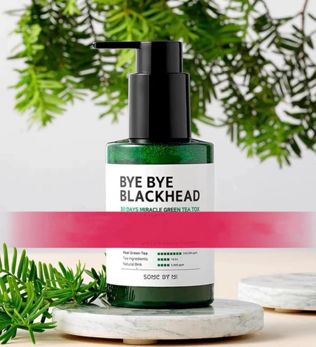 Person applying green tea facial cleanser with foam on face holding green bottle with black pump